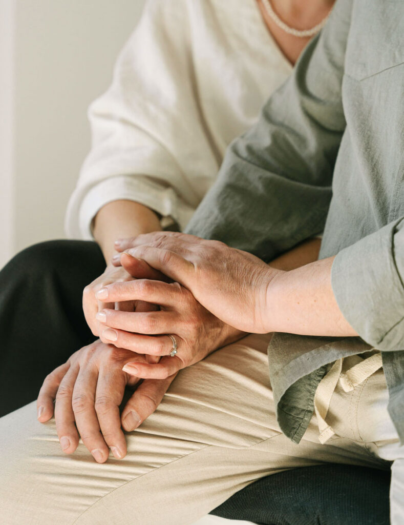 Elderly wife and husband holding hands.