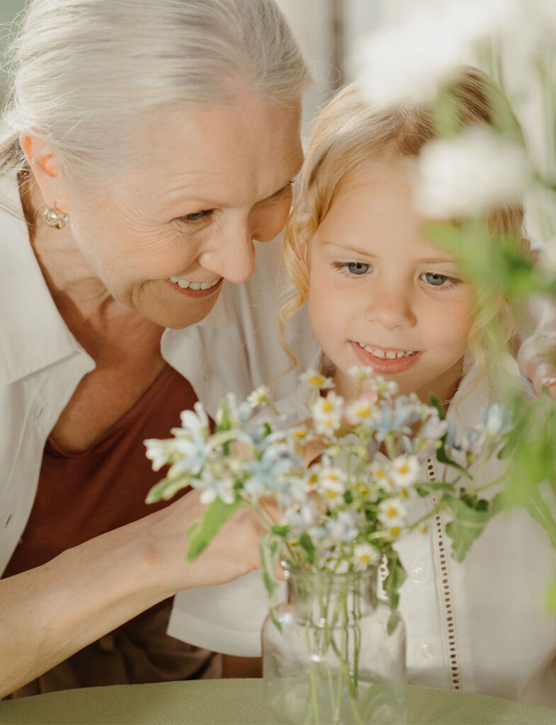Grandma showing granddaughter flowers.